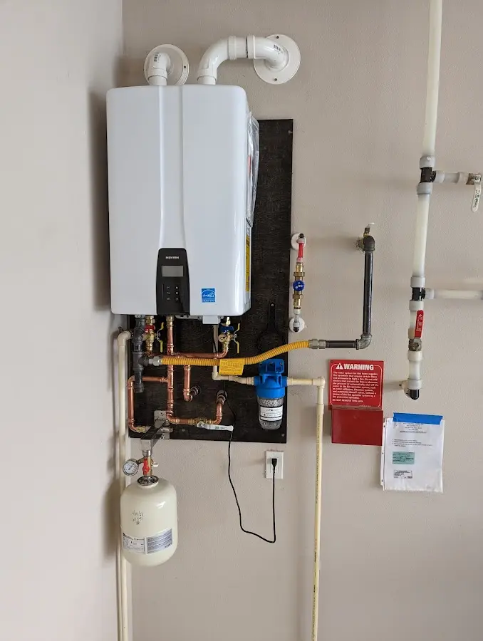 Professional plumber installing copper piping in a Howe home